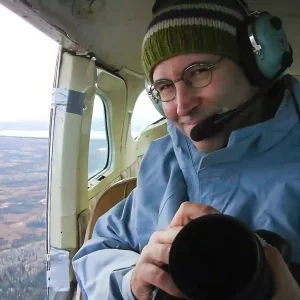 Garth Lenz can be seen here in a helicopter while on a conservation photography assignment. Garth is an acclaimed landscape photographer and conservation photographer who guides as a photography instructor for Nature Talks UK.